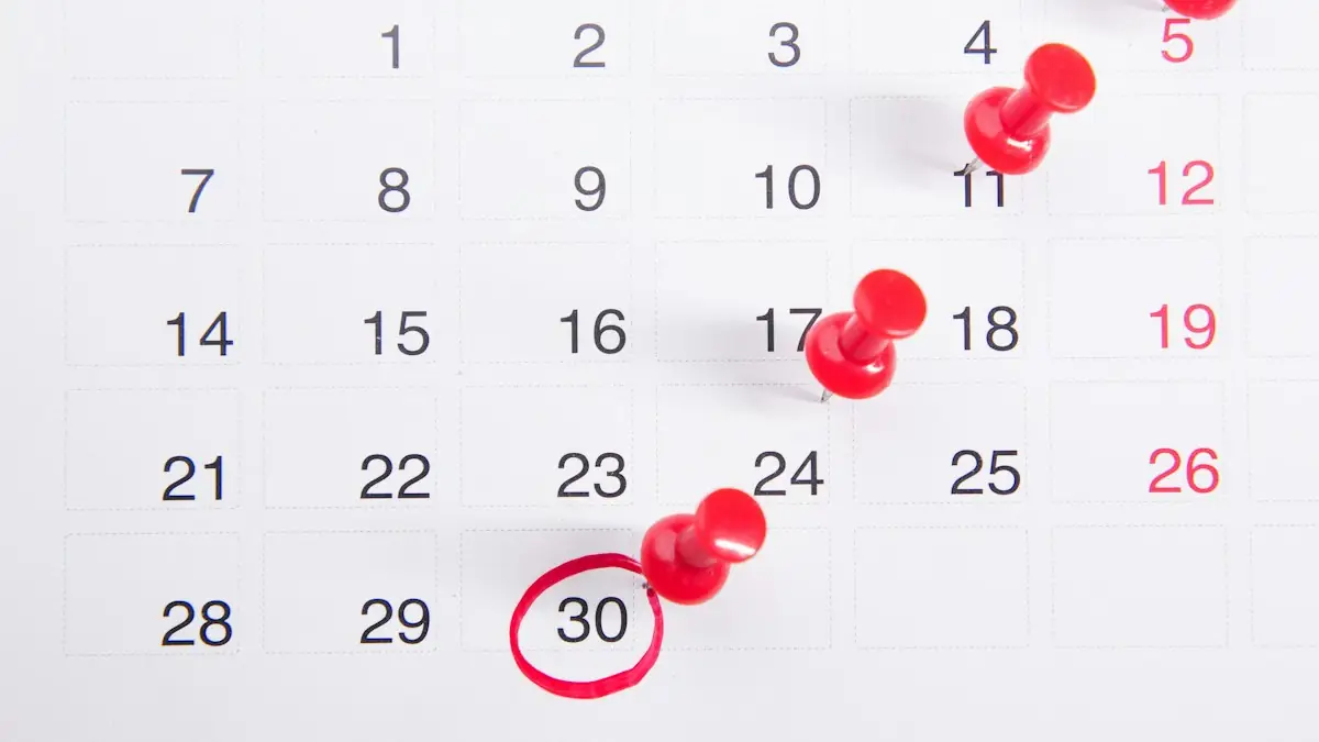 A calendar with red push buttons pinned to it